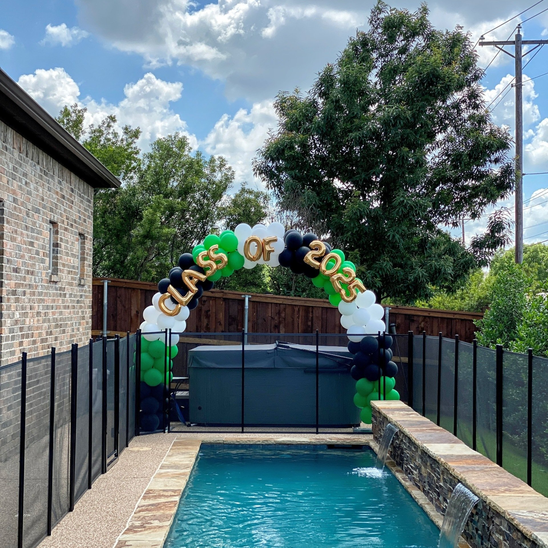 A class of 2020 balloon arch over a pool