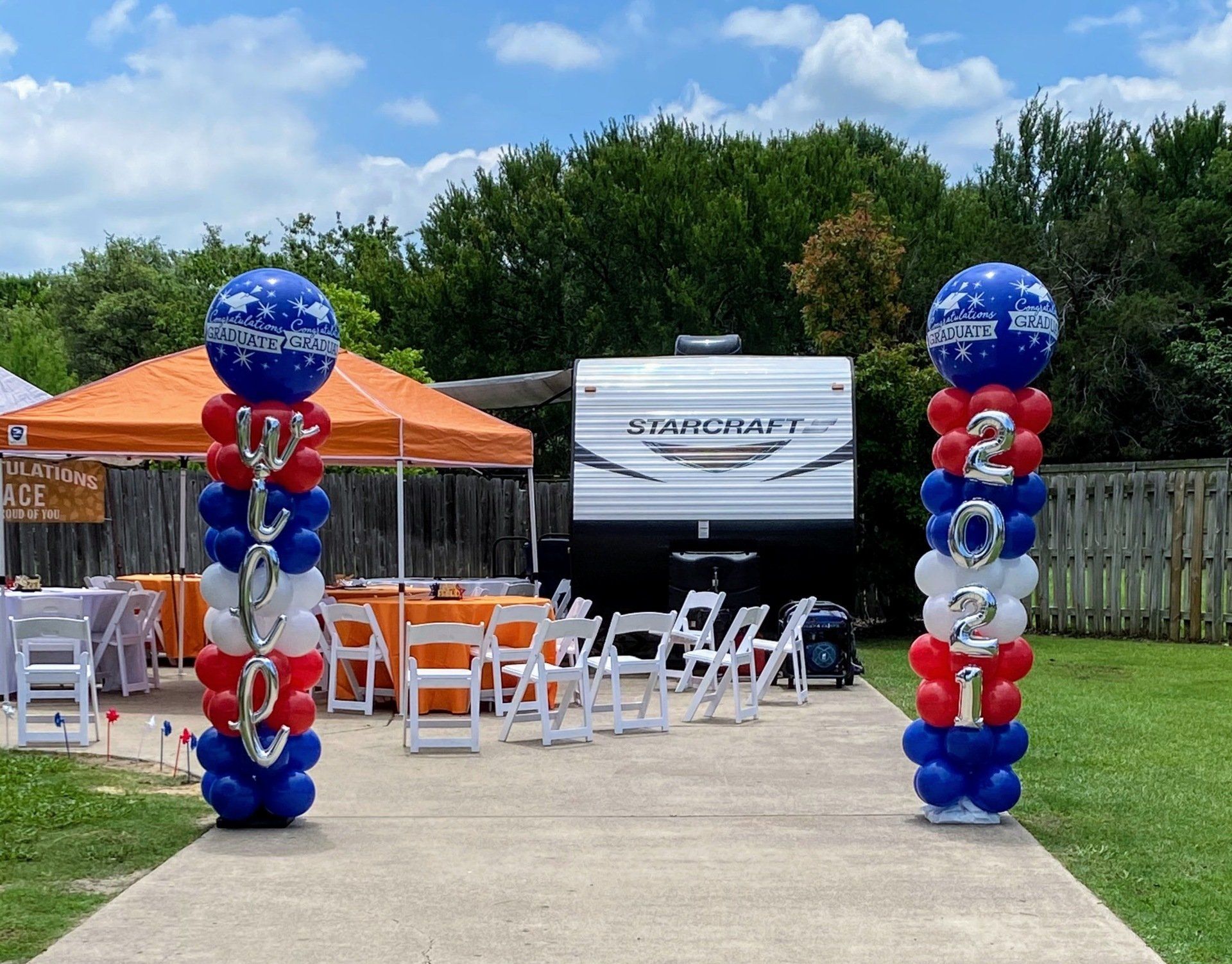 A red white and blue balloon display with a trailer in the background