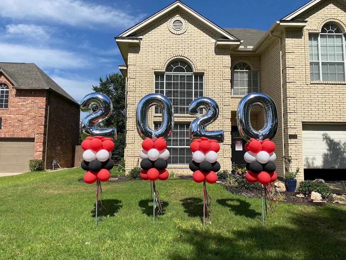 A house with balloons in front of it that say `` 2020 ''.