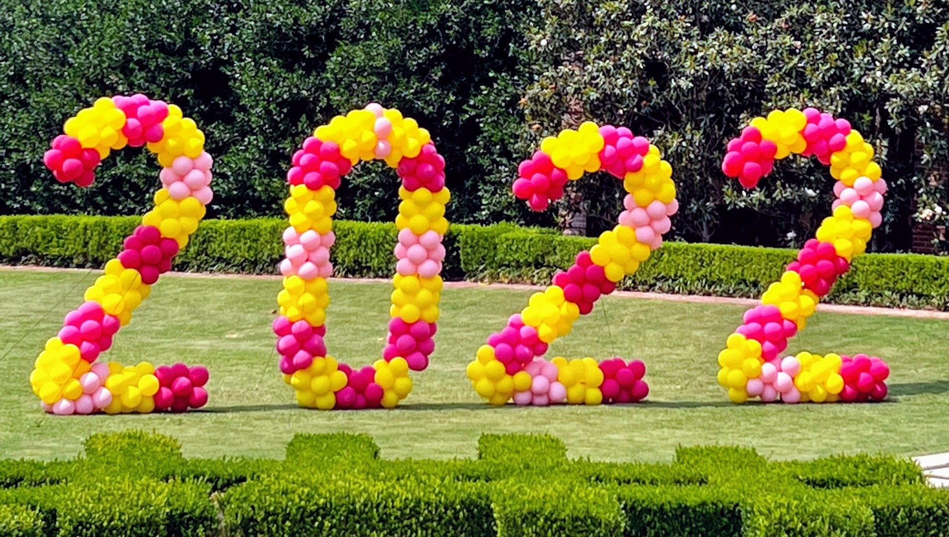 The number 2022 is made out of pink and yellow balloons