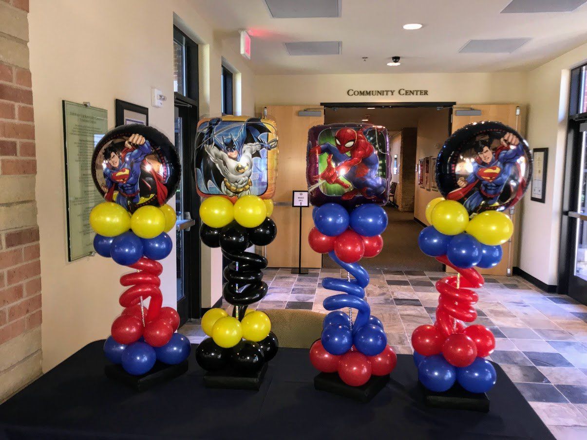 A bunch of balloons are sitting on a table in a hallway.