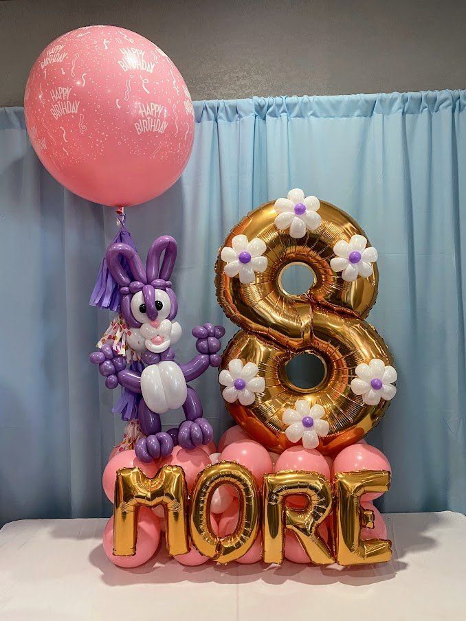A bunny made out of balloons is standing next to a number 8 and the word more.