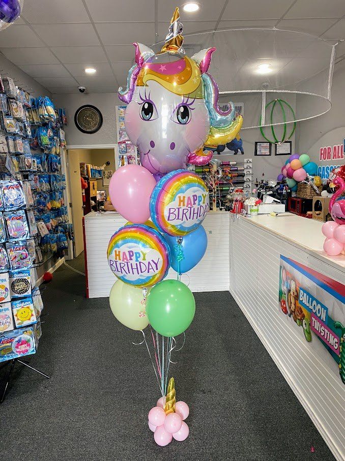A bunch of balloons are sitting on a table in a store.