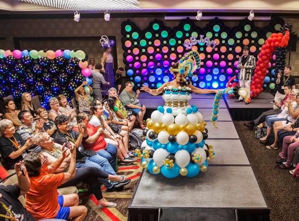 A woman is walking down a runway made of balloons.