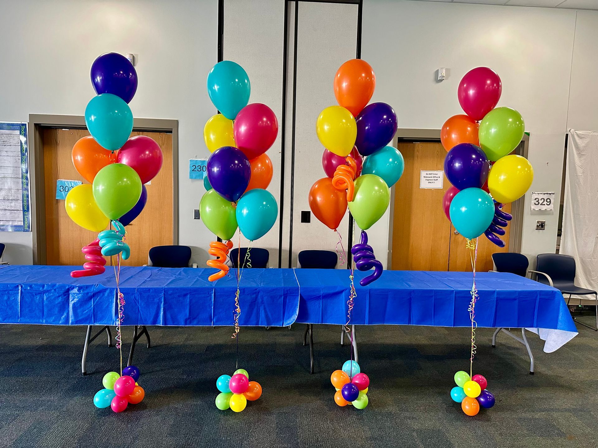 Three bunches of colorful balloons are sitting on top of a table.