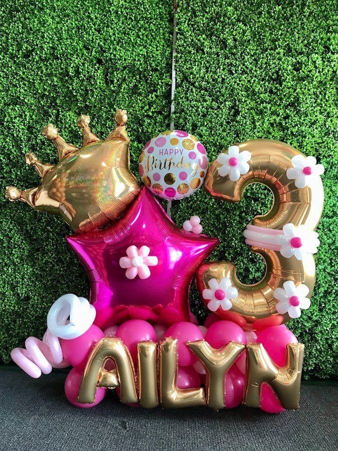 A bunch of pink and gold balloons with the name ailyn on them.
