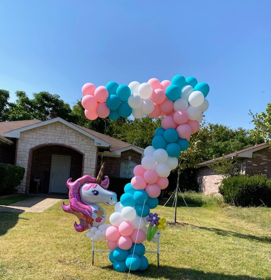 A unicorn balloon is surrounded by balloons in the shape of the number 7