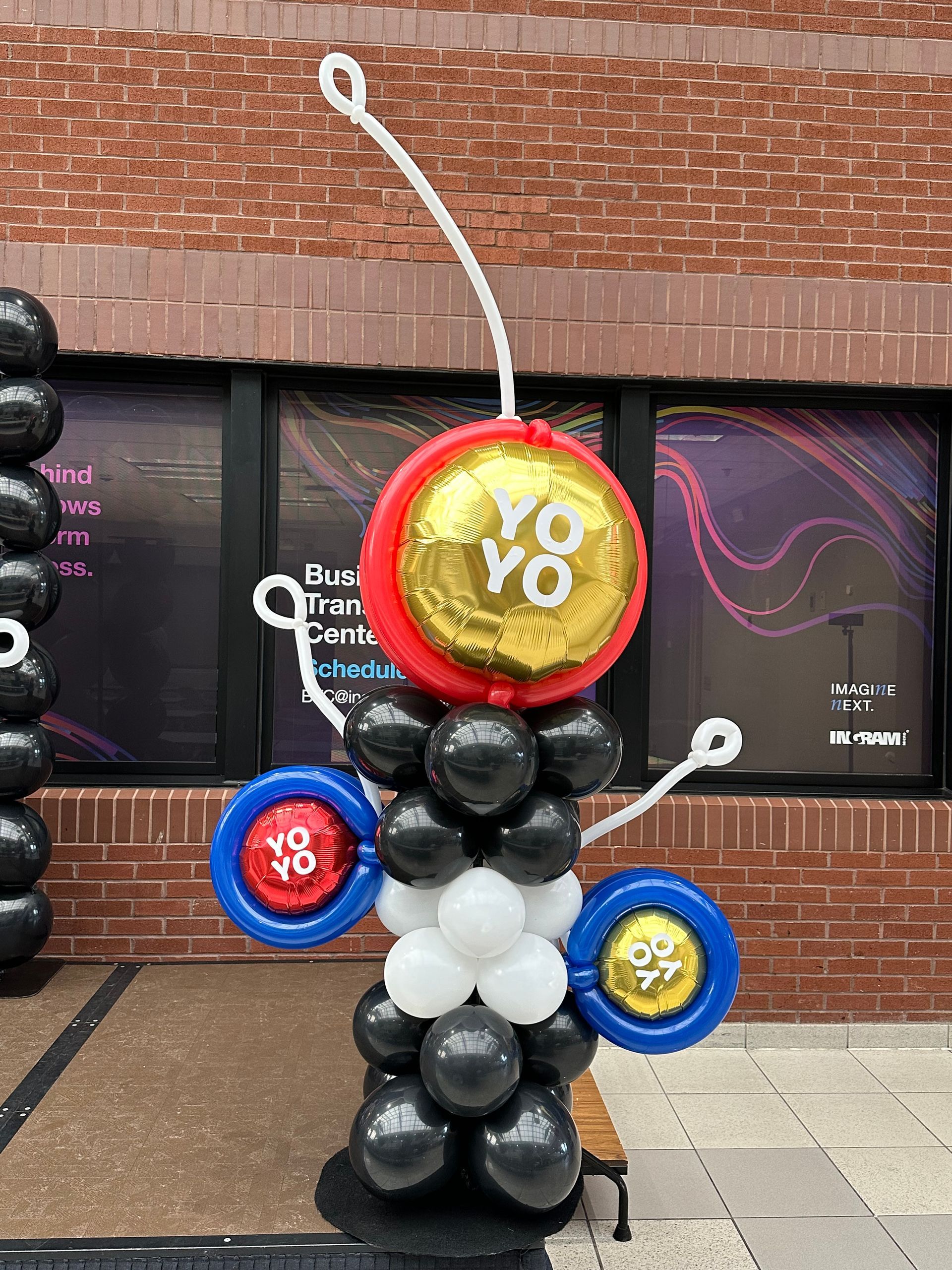 A balloon sculpture is sitting in front of a brick building.