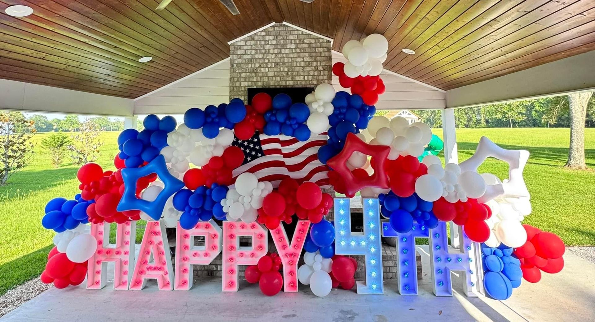 A large display of red , white , and blue balloons and letters that say `` happy 4th ''.