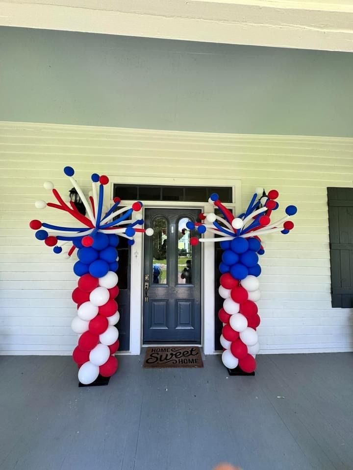 Red white and blue balloons are lined up in front of a door