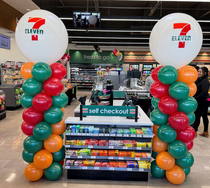 Branded balloon columns for a 7-Eleven grand opening in Fort Worth, featuring custom company colors and logo balloon toppers.