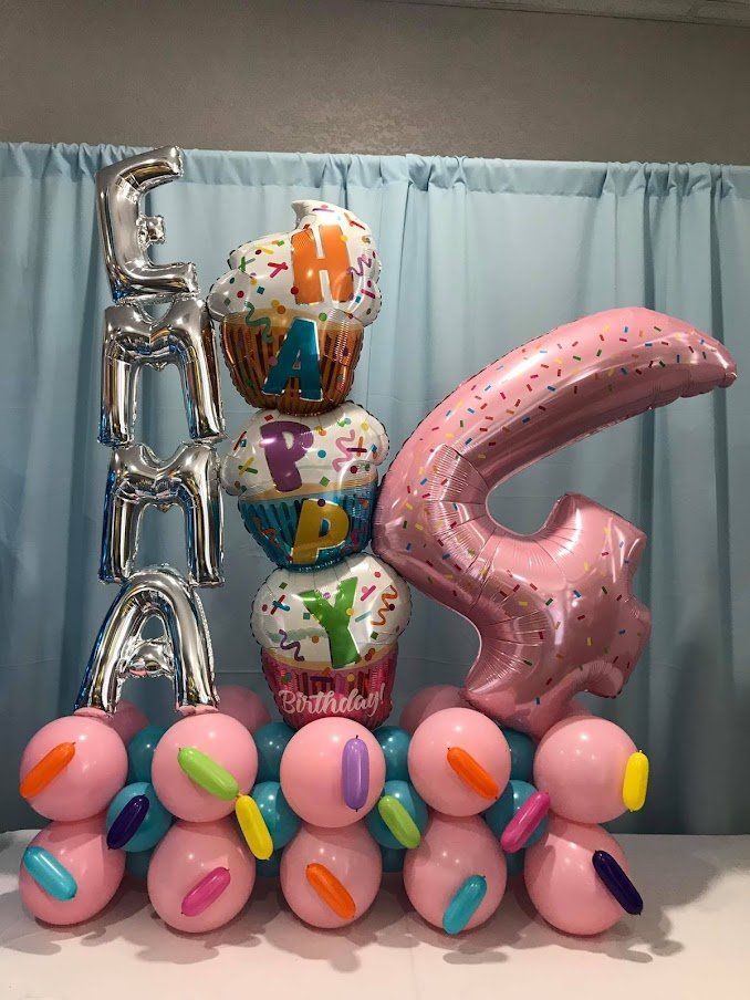 A bunch of balloons are stacked on top of each other on a table.