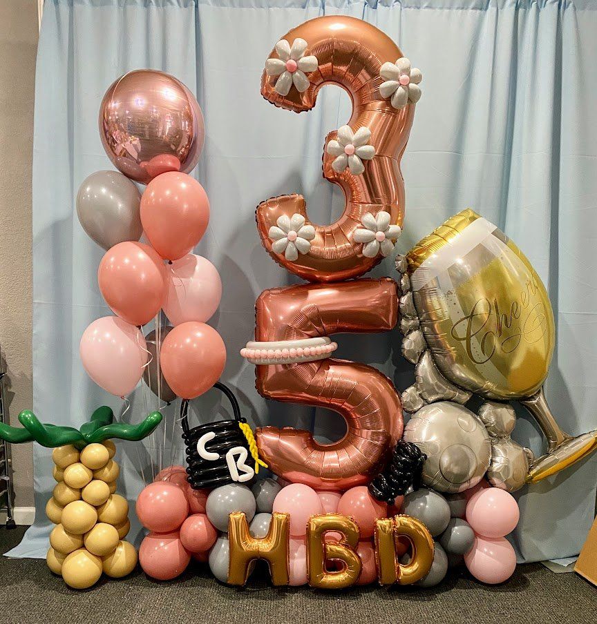 A room filled with balloons and letters that say hbd.