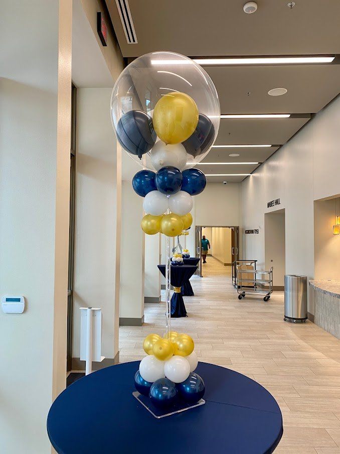 A balloon display is sitting on a table in a hallway.