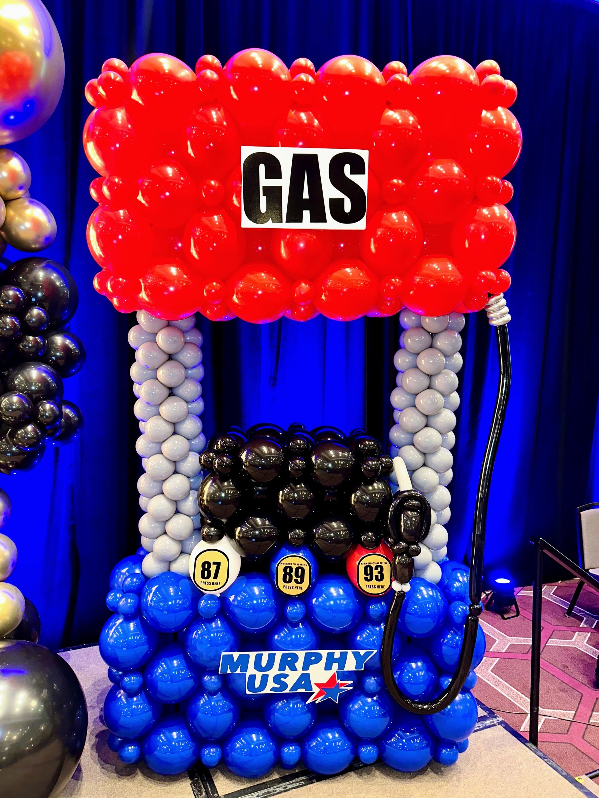 A gas pump made out of balloons is sitting on a table.