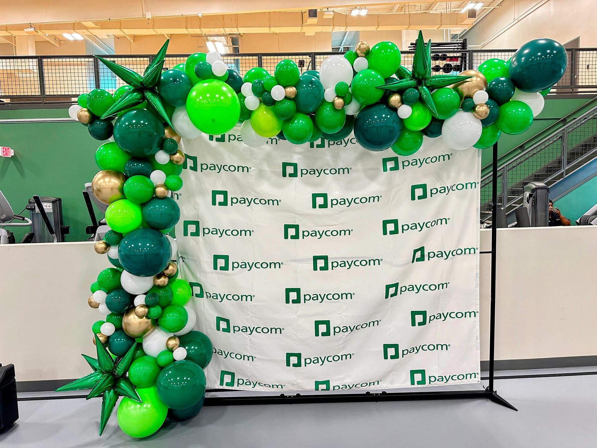 A bunch of green balloons are sitting on top of a white cloth.