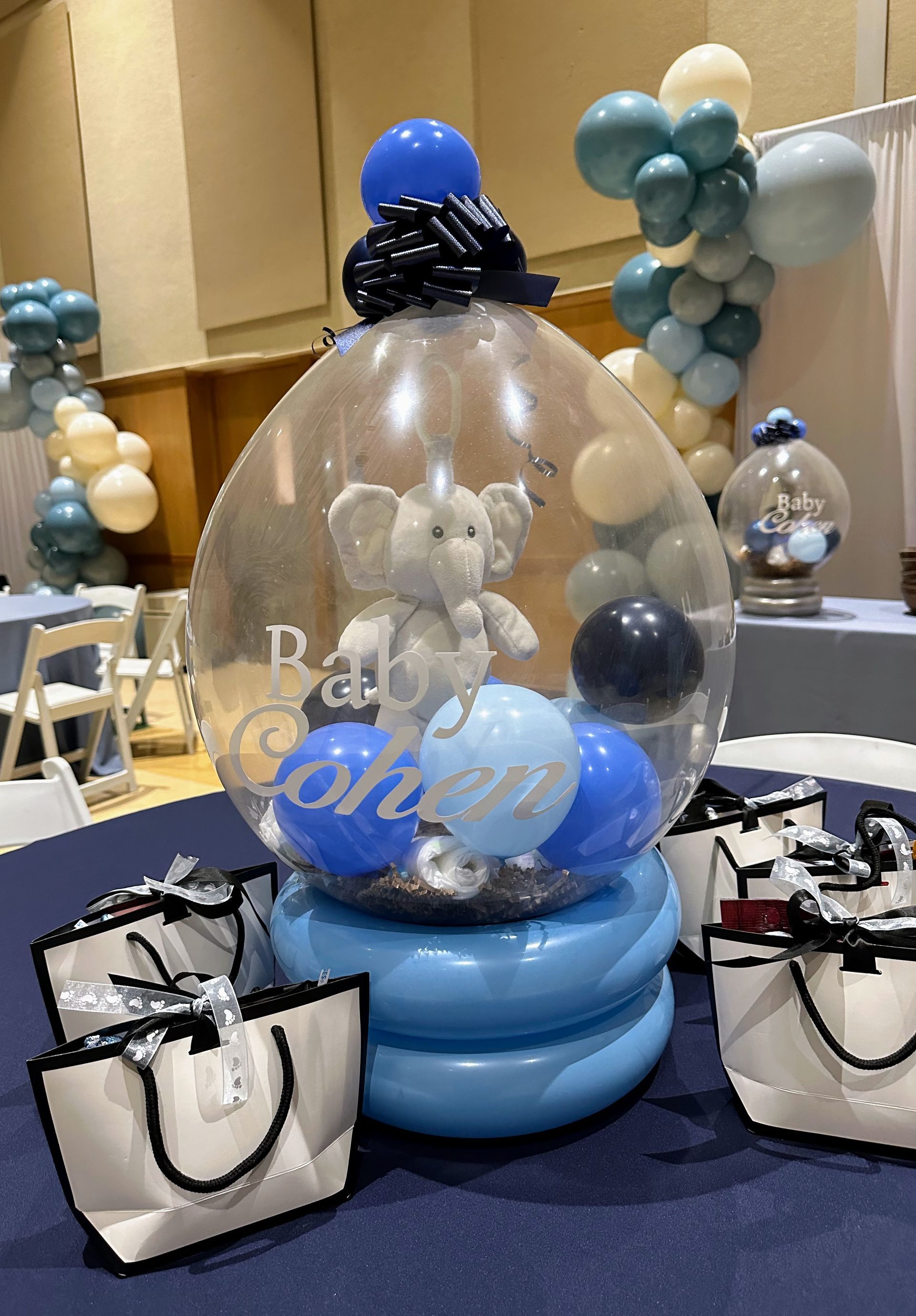 A clear balloon with an elephant inside of it is sitting on a table.