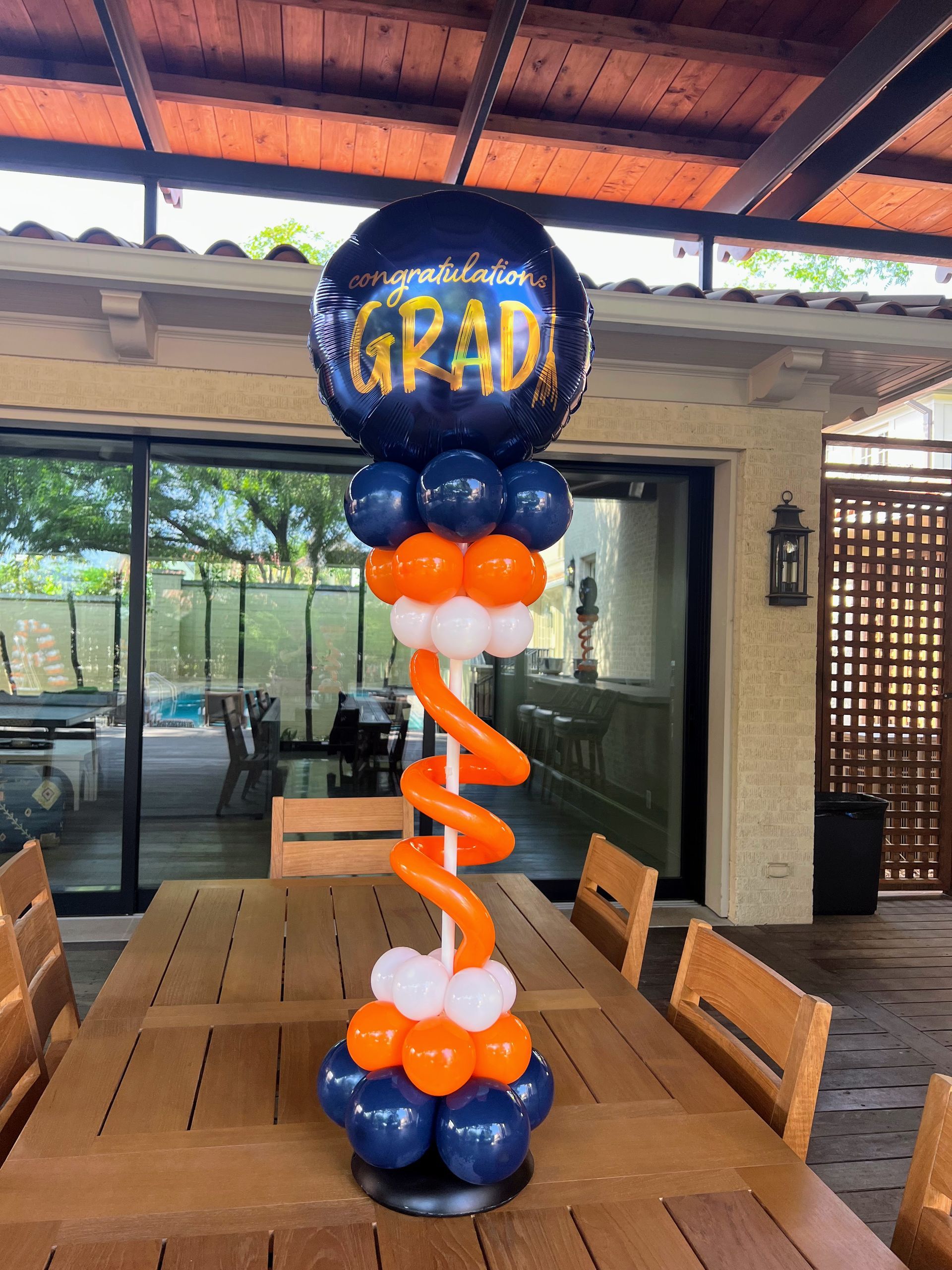 A table topped with balloons and a balloon that says congratulations grad
