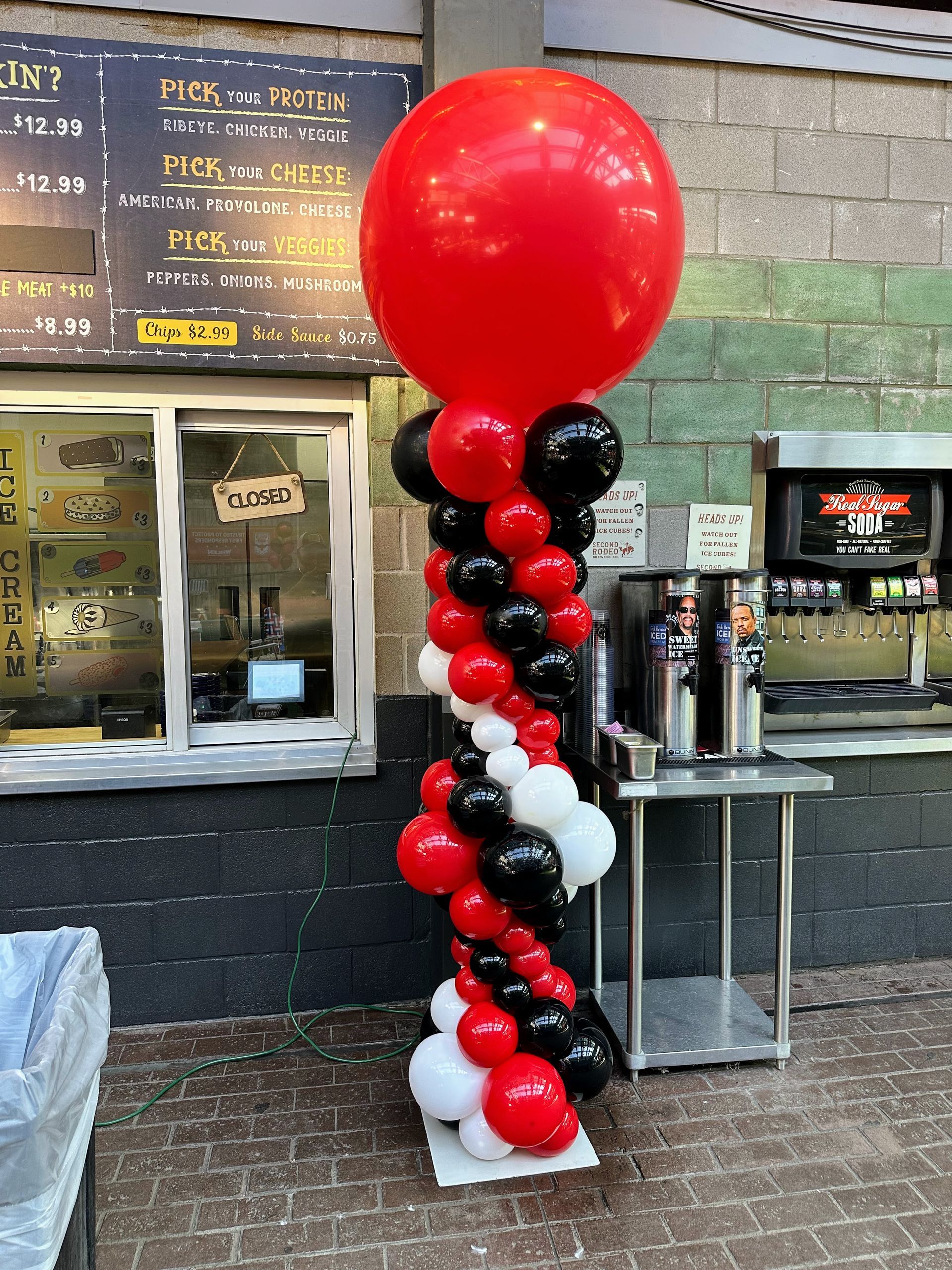 Custom red black and white balloon column for corporate event installation inside a commercial venue