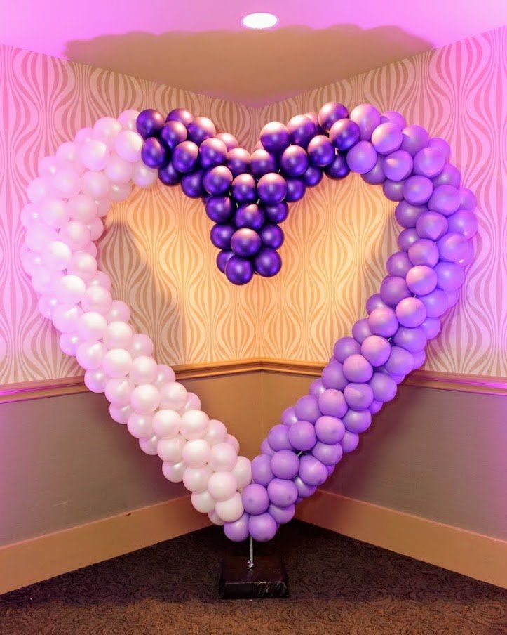 A large heart made of purple and white balloons