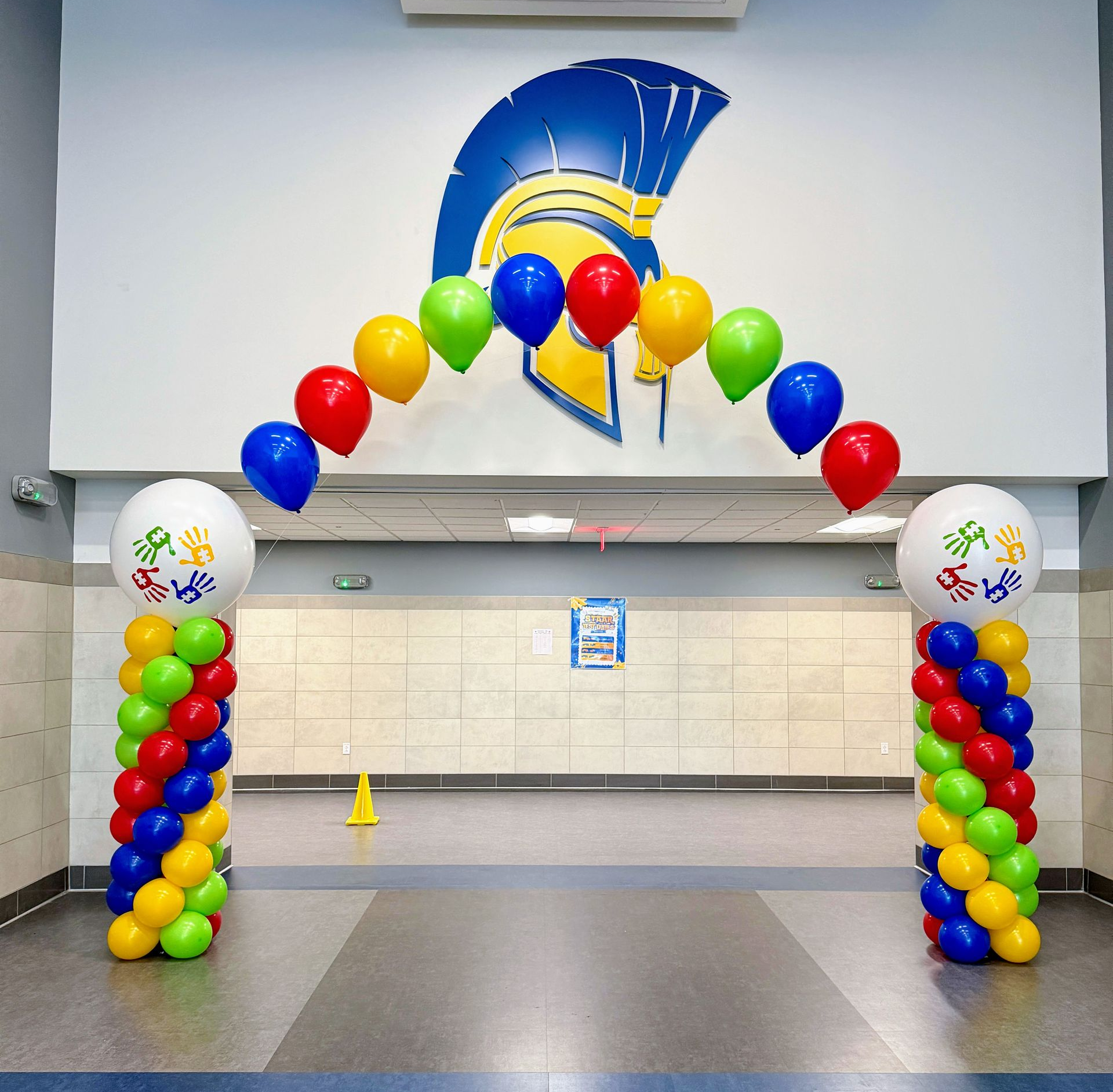 Autism awareness balloon arch in a string of pearls style with colorful balloon columns and matching personalized vinyl.