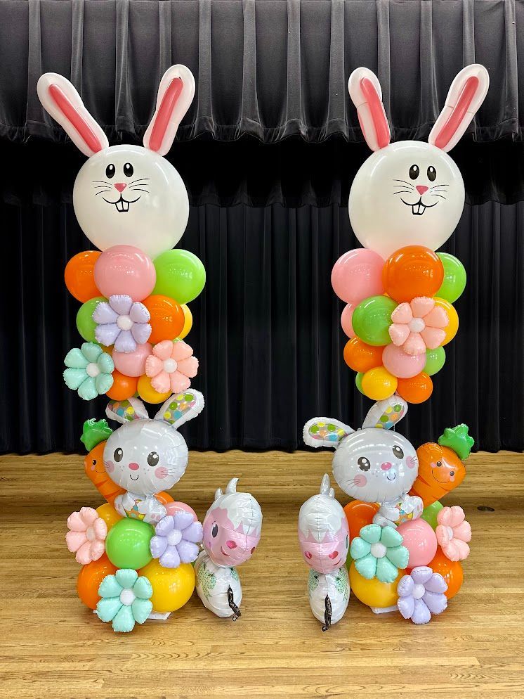 A couple of bunnies made out of balloons on a stage.