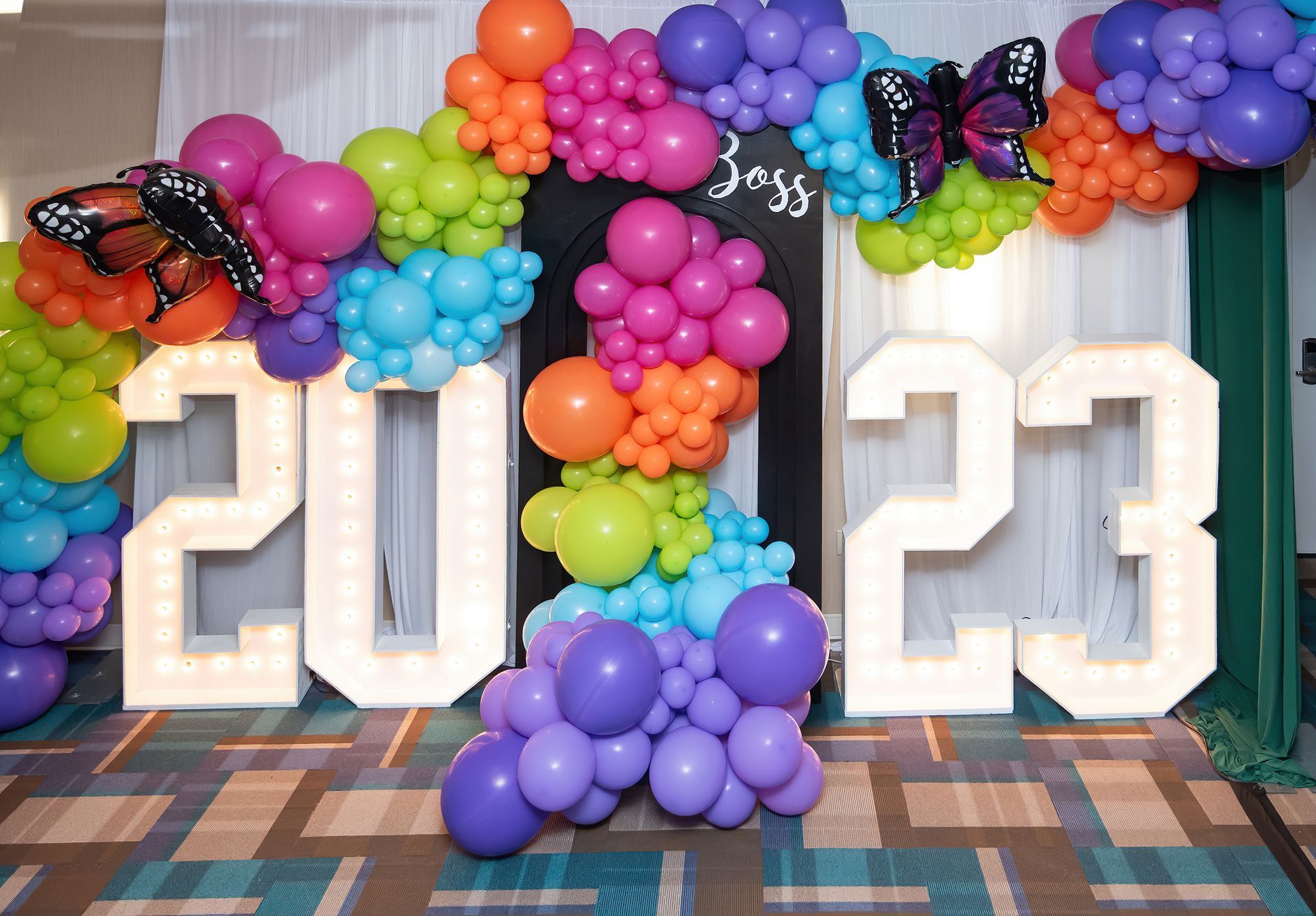 A room filled with balloons and a sign that says 2023