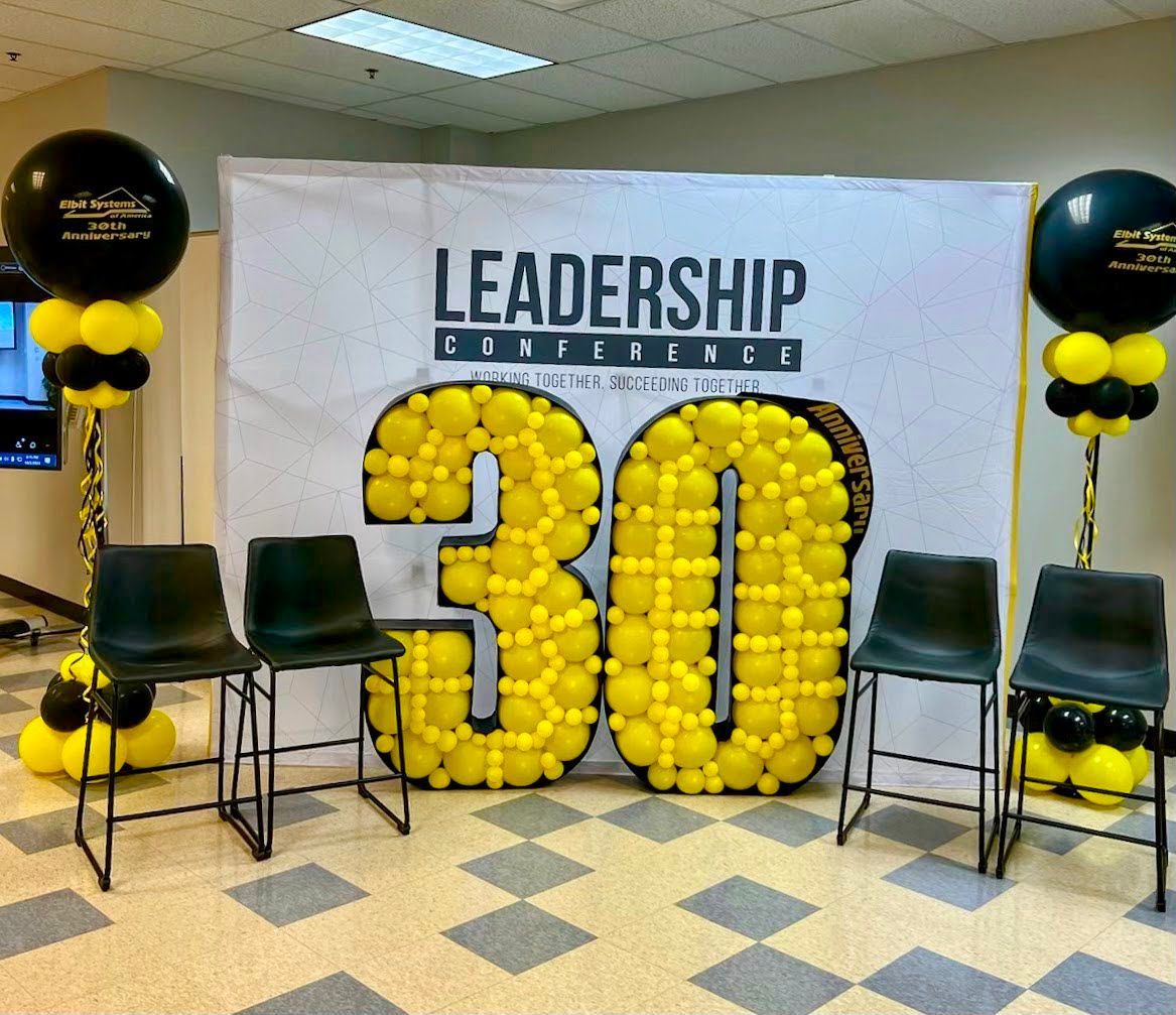 A room with chairs and balloons and a sign that says leadership conference