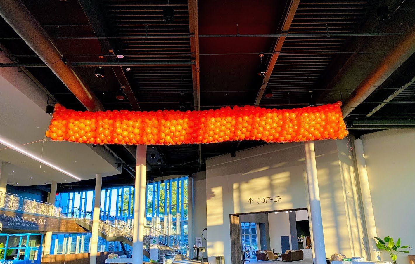 A large red chandelier is hanging from the ceiling of a building.