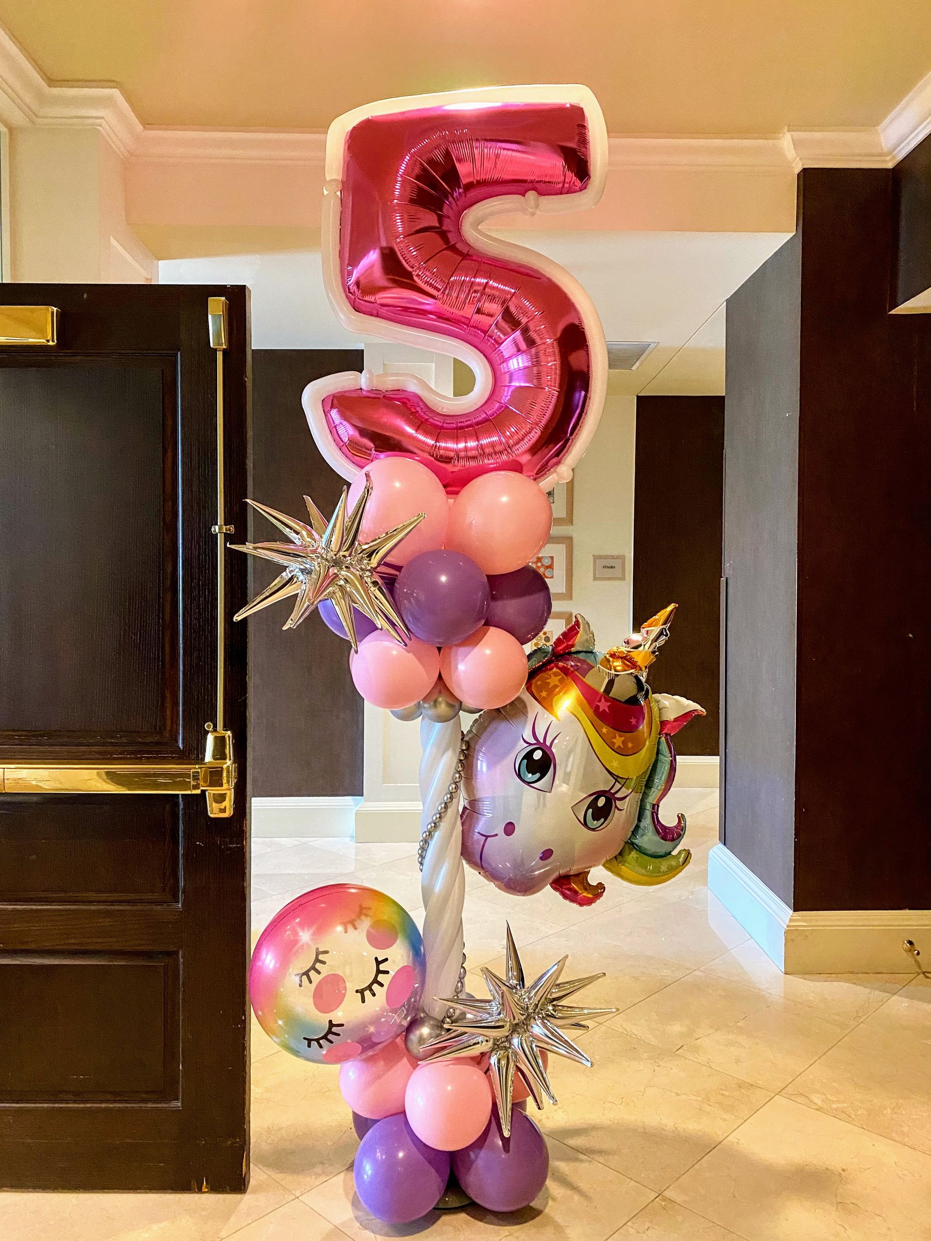 A bunch of pink and purple balloons with a number 5 on top of them.