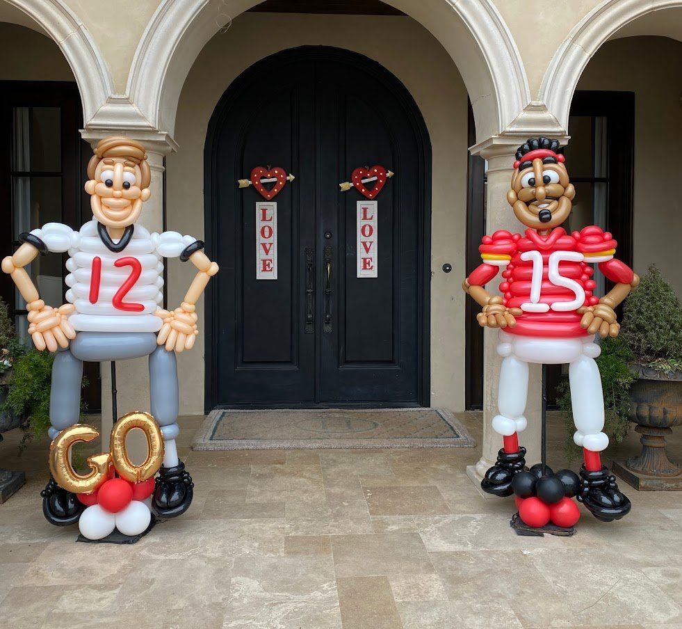 Two football players made out of balloons with the number 12 and 15 on their shirts