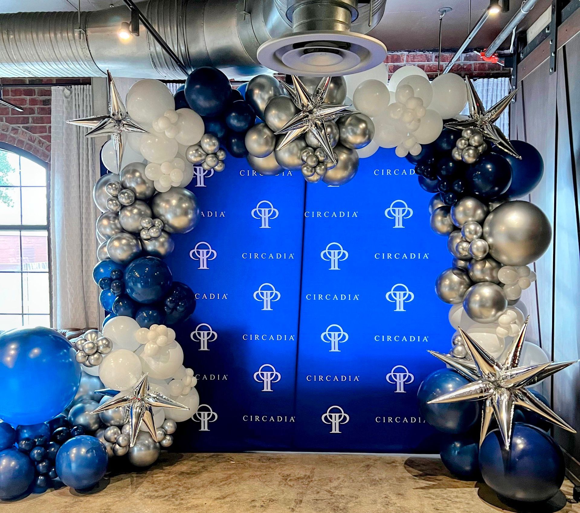A blue wall is decorated with balloons and stars