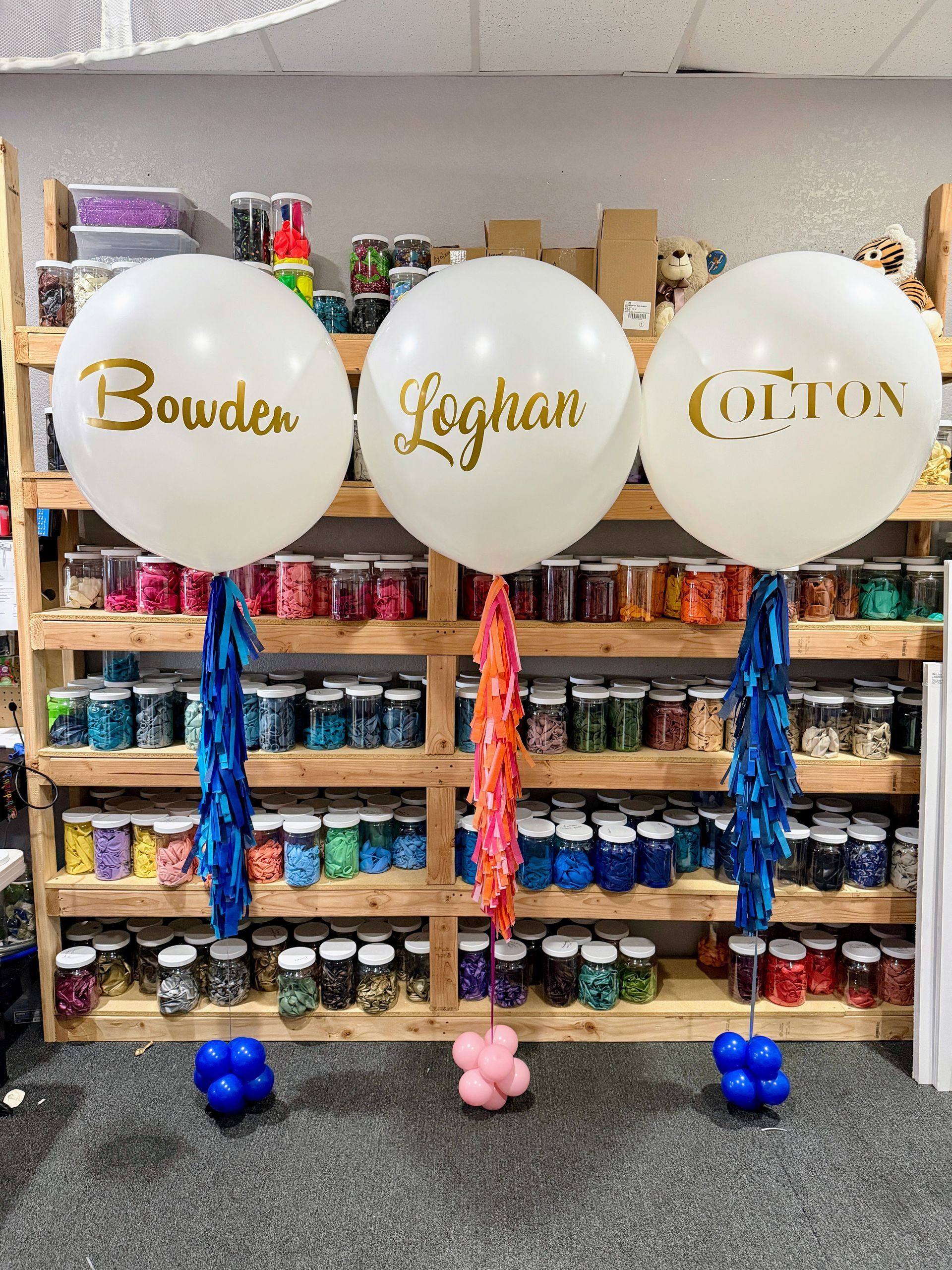 personalized helium jumbo balloons with vinyl names in gold, and tassels.