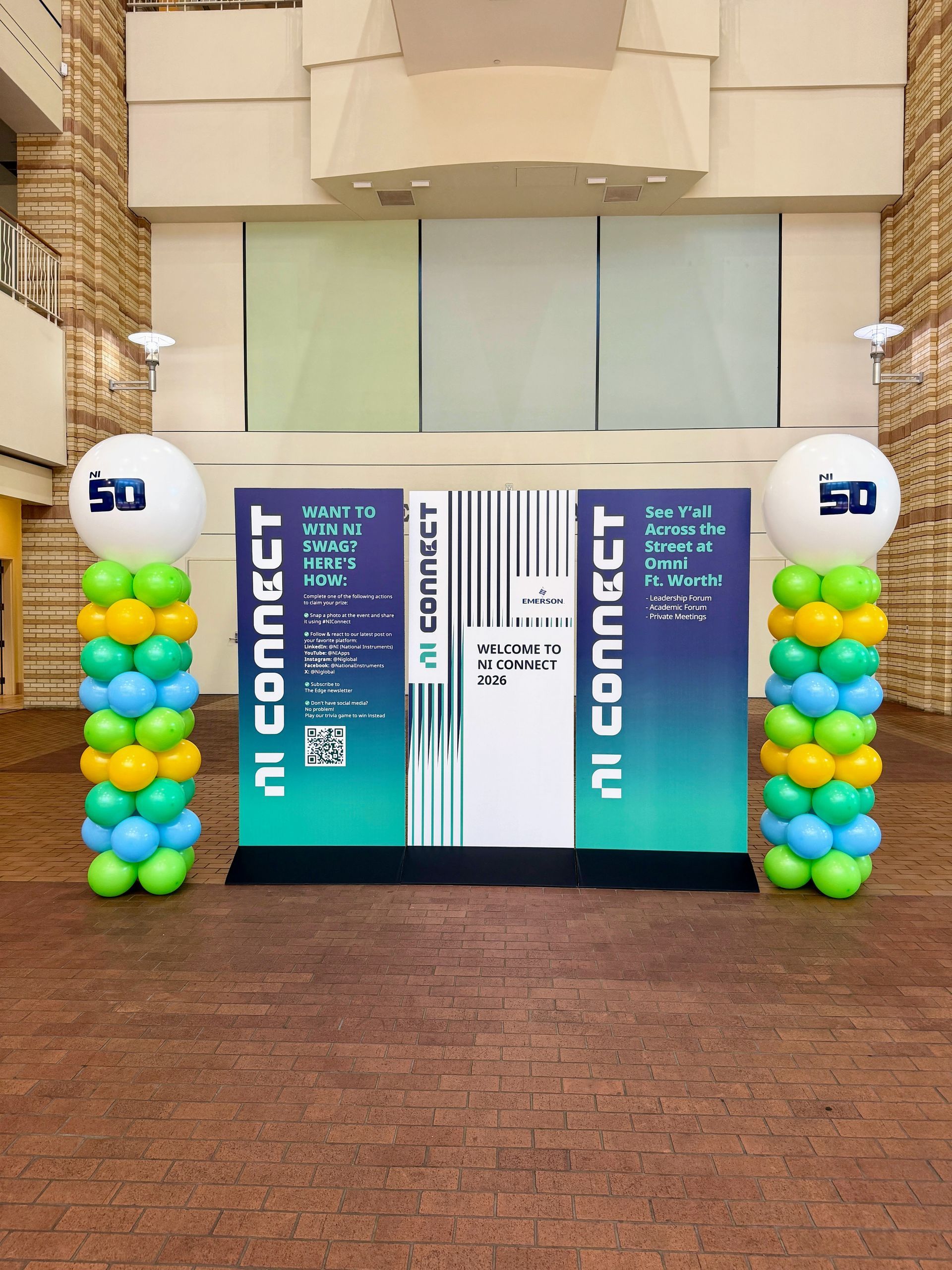 Corporate balloon column decor in company colors and a company logo with backdrop.