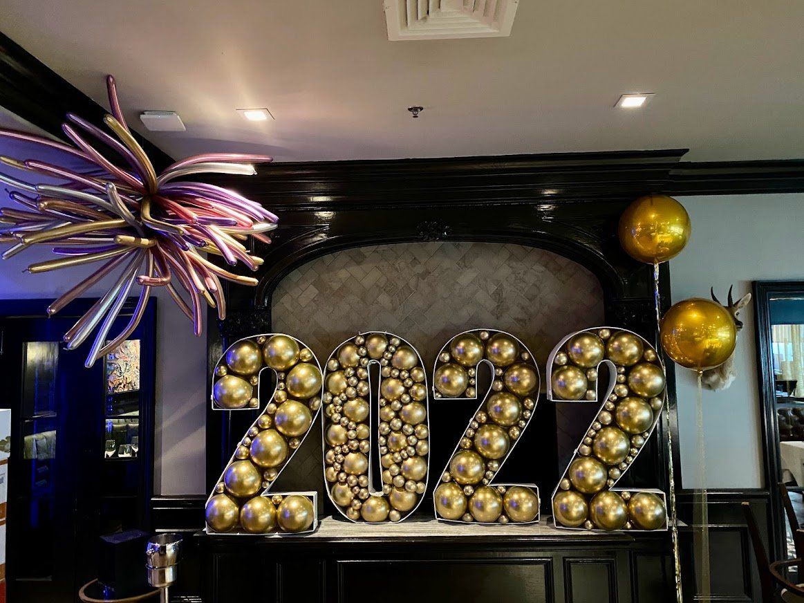 A large sign that says 2022 made of balloons in a room.