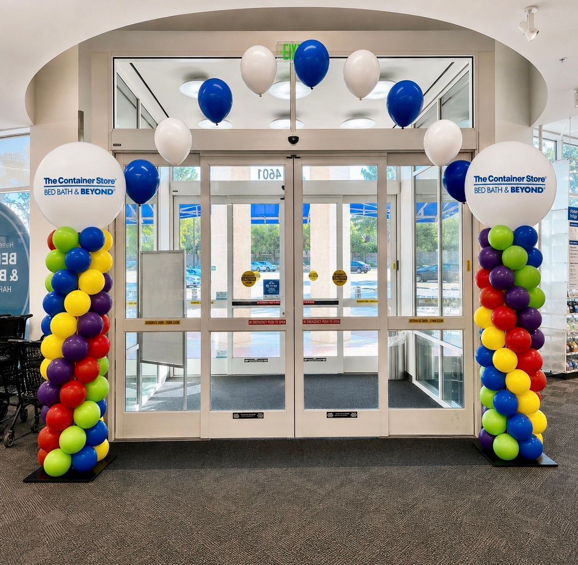 A corporate style string of pearls balloon arch attached to balloon columns in company colors.
