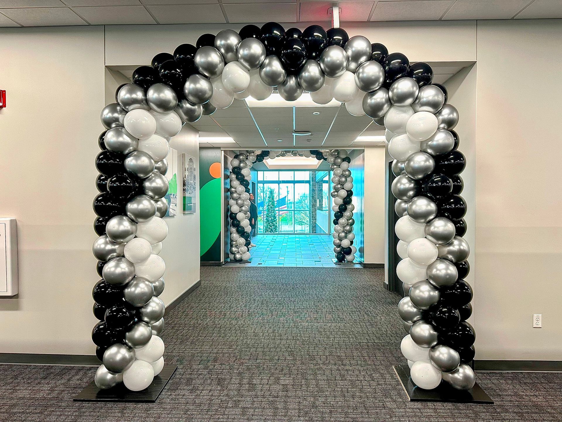 Modern silver white and black balloon arch entrance for corporate event or business conference