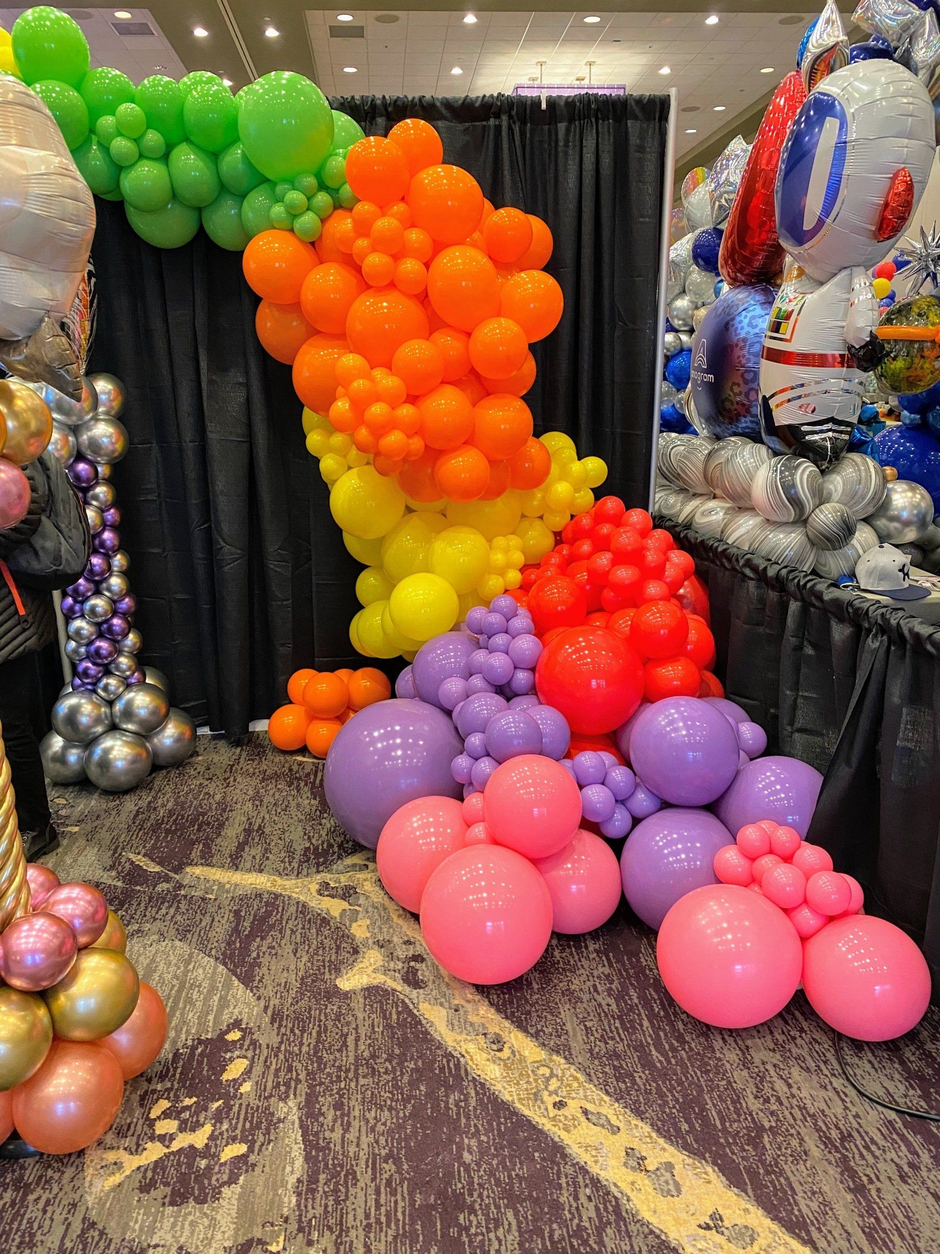 A bunch of balloons are sitting on the floor in a room.