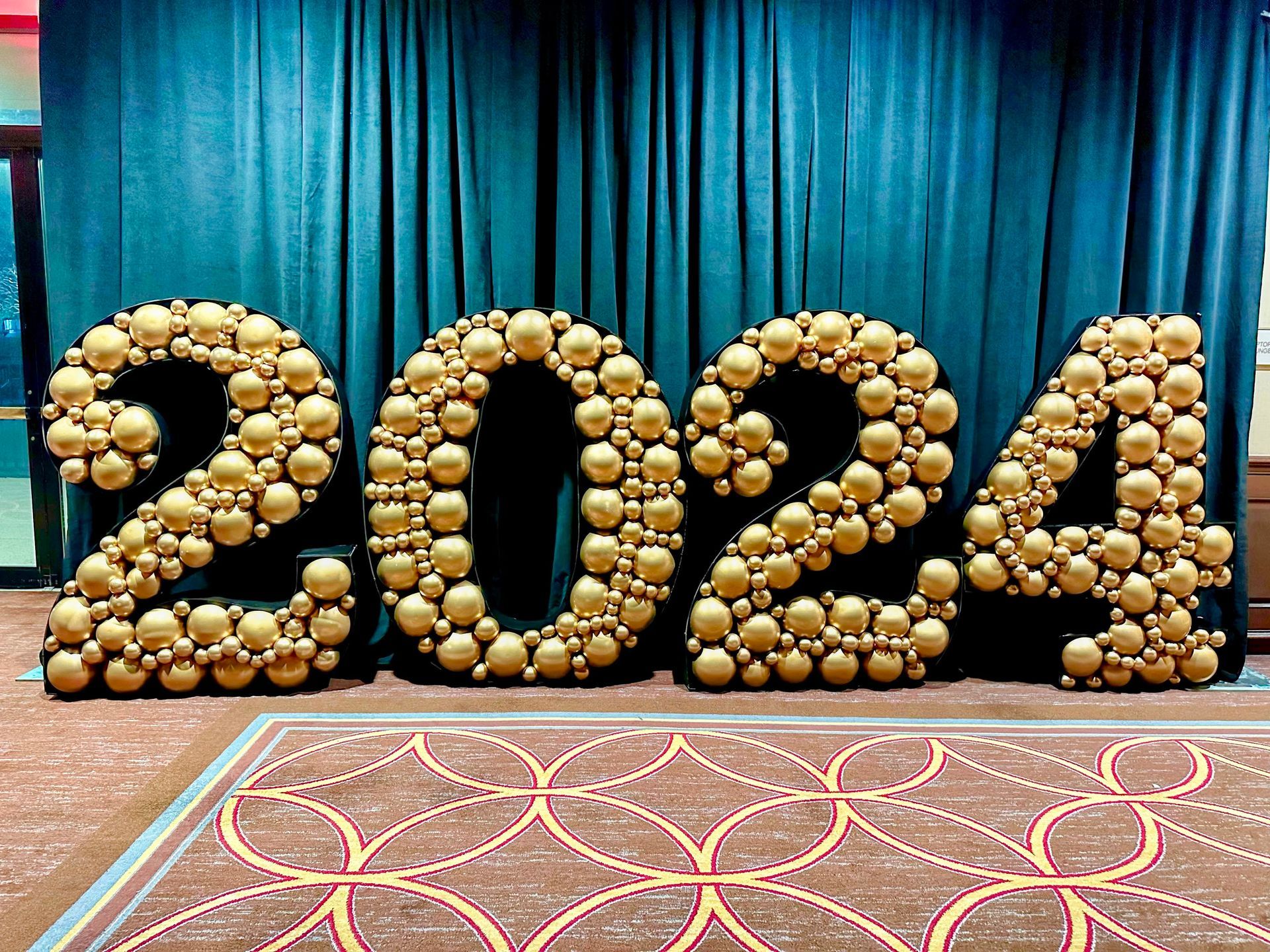 The numbers 2024 are made out of gold balloons.