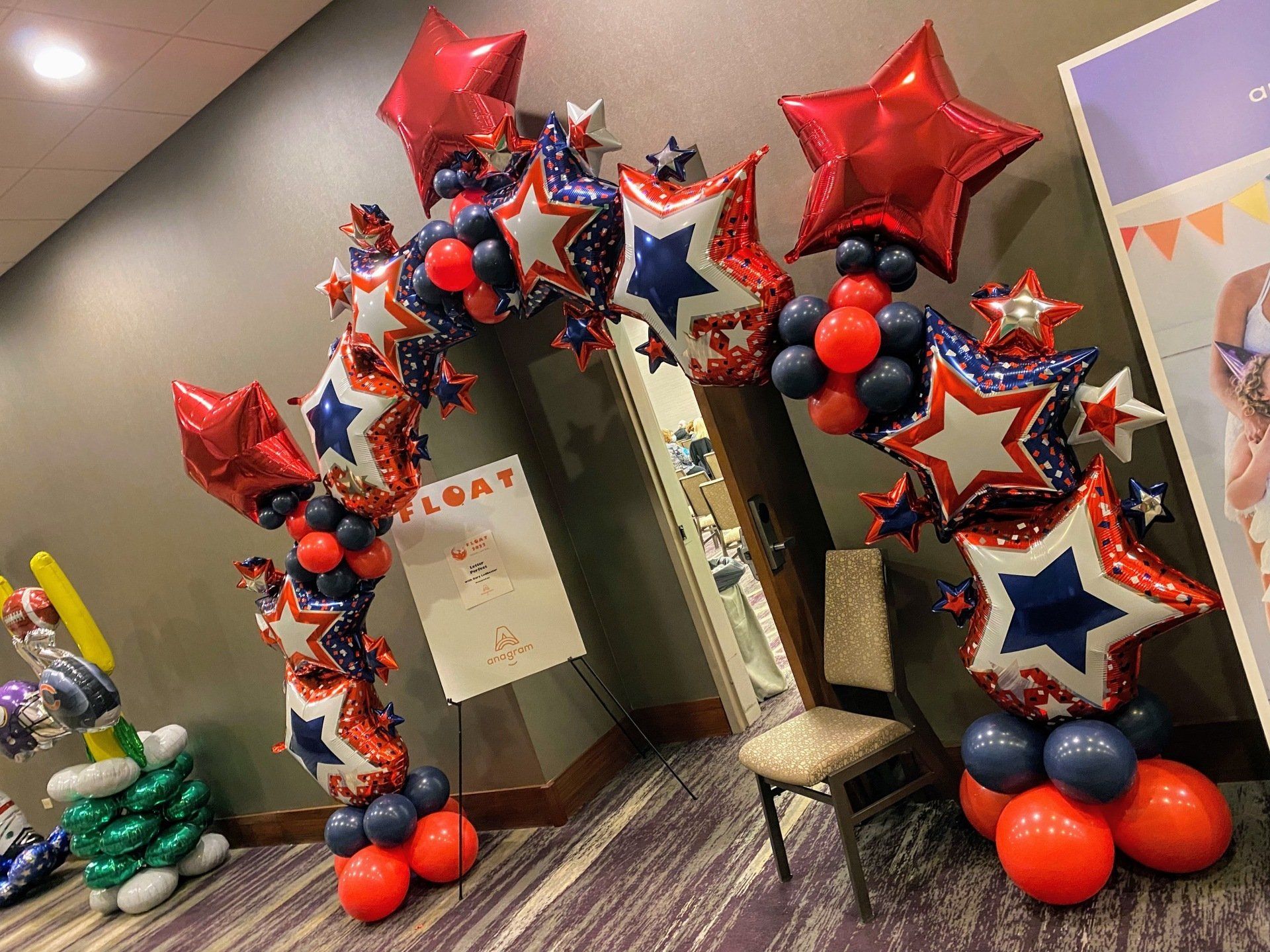 A room filled with red , white , and blue balloons.