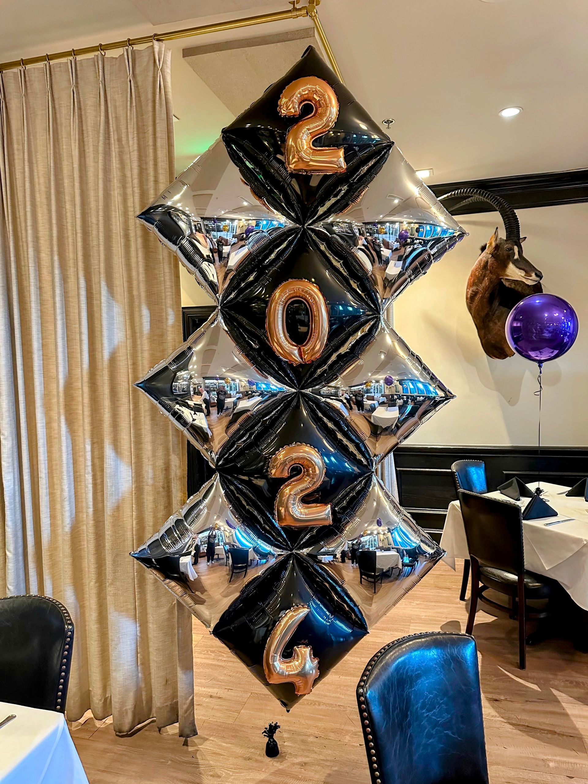 A bunch of balloons hanging from the ceiling in a room.