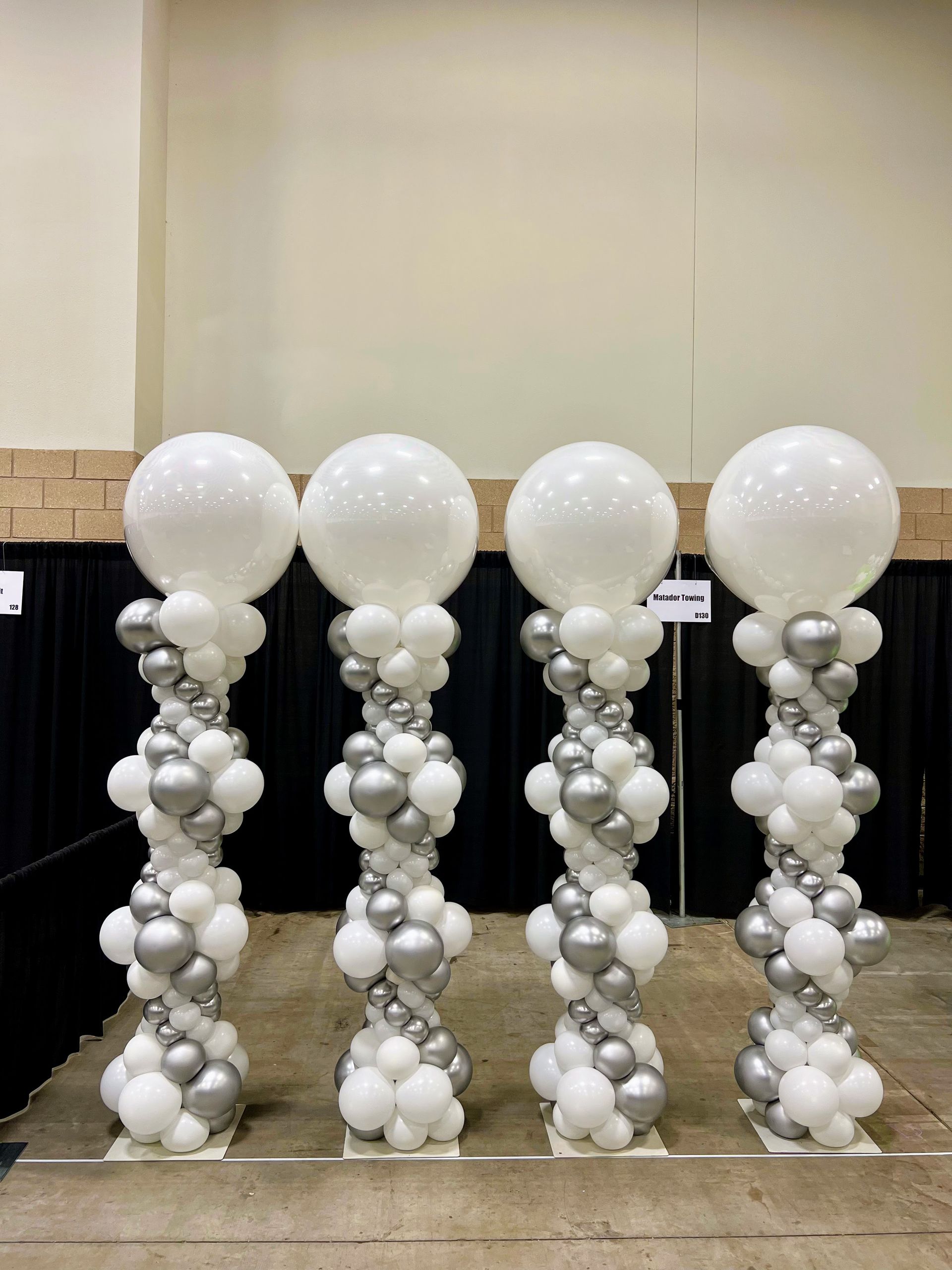 Classic Silver and white balloons column decor for an indoor event, elevating the celebration.