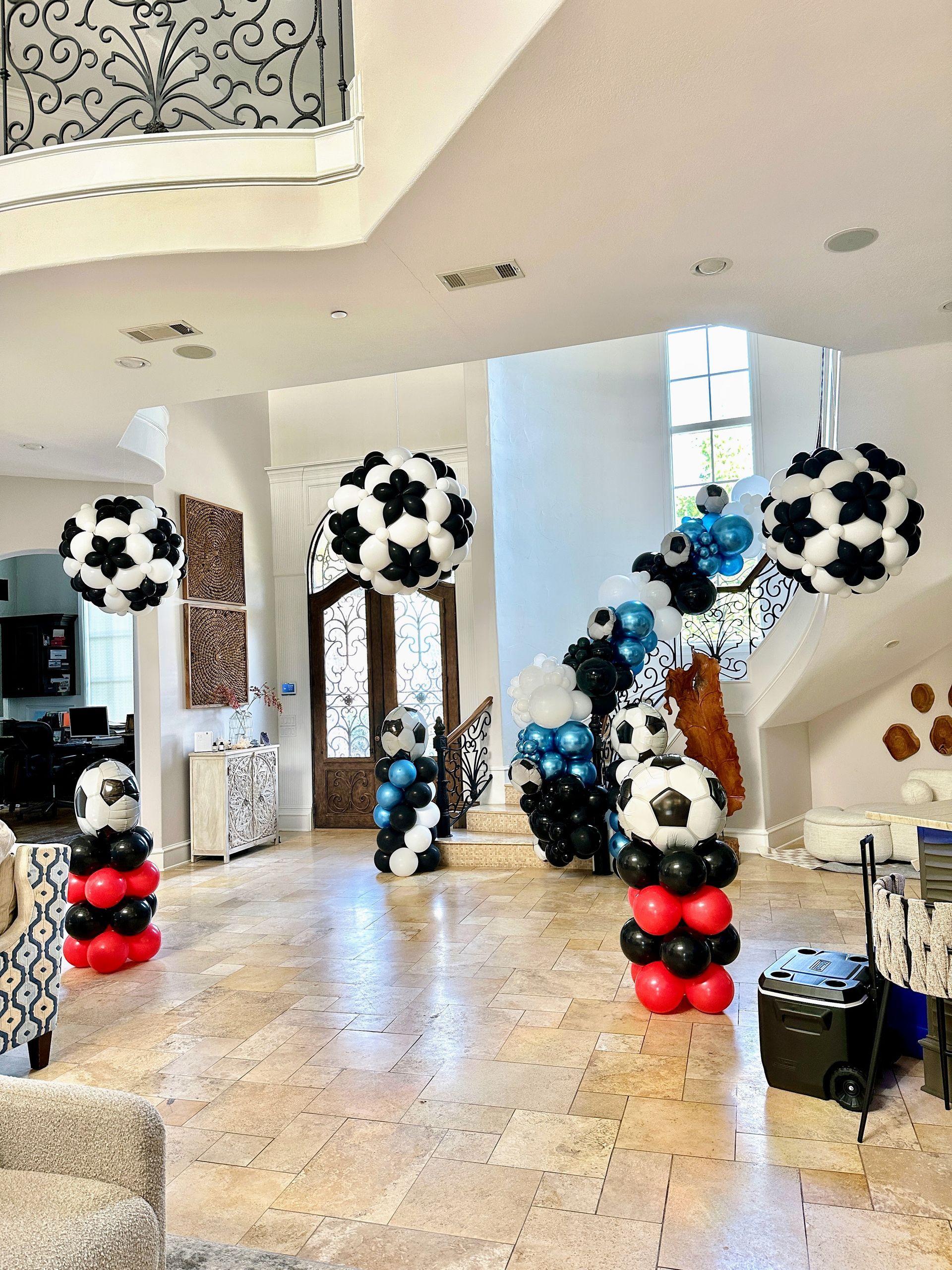 Balloon soccer balls hanging from the ceiling with soccer ball balloon columns