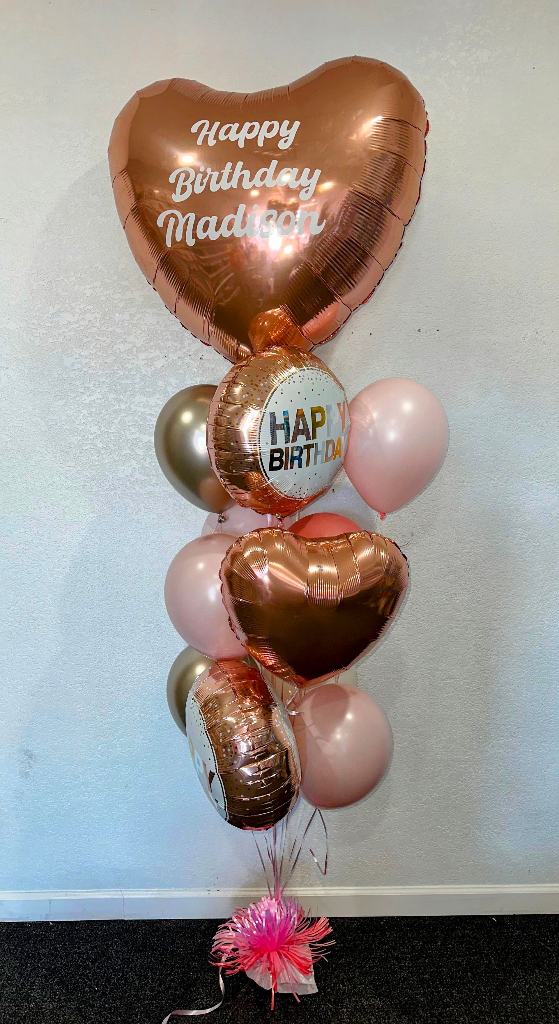 A bunch of balloons are sitting on the floor in front of a wall.