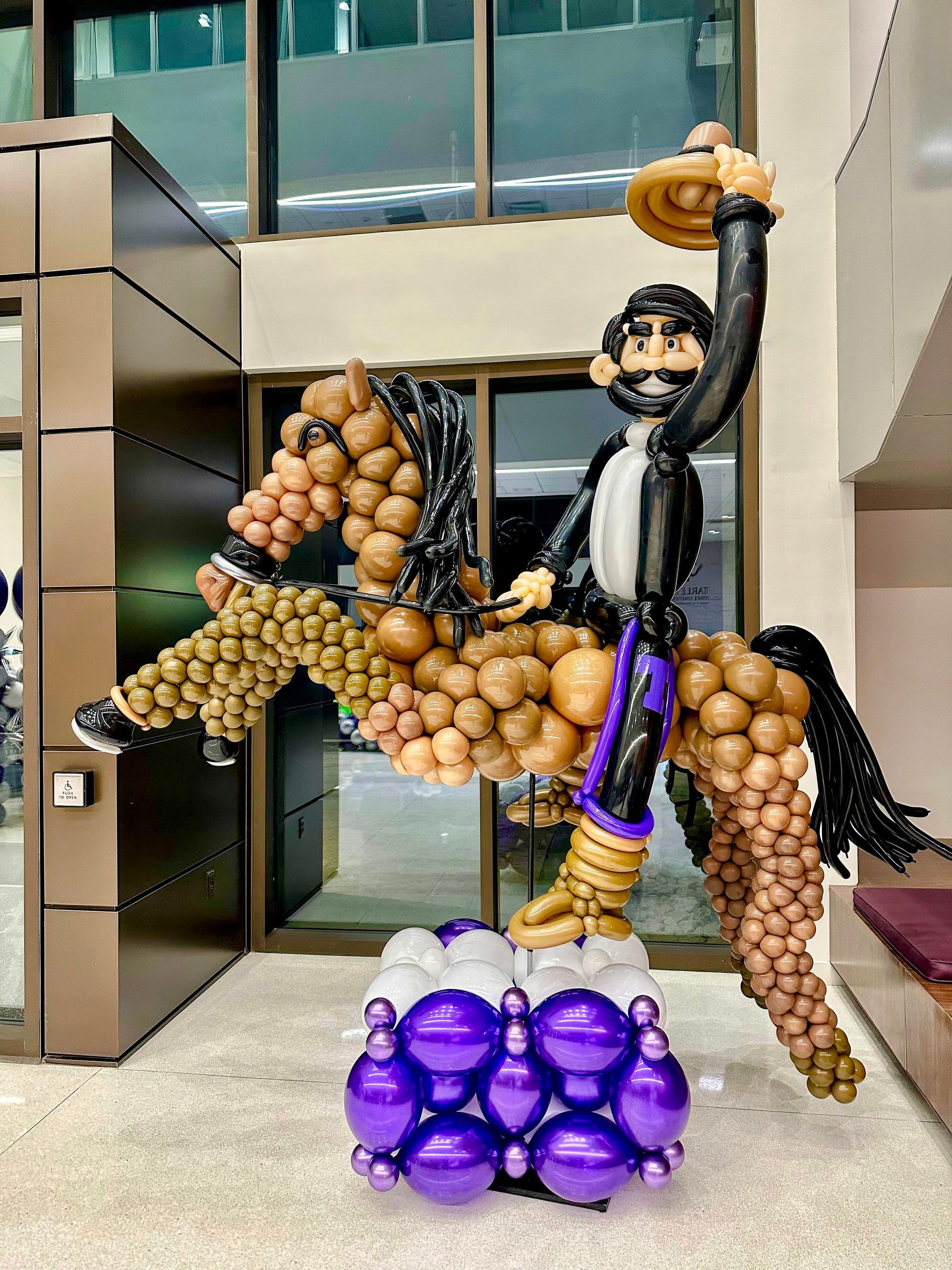 A statue of a man riding a horse made of balloons.