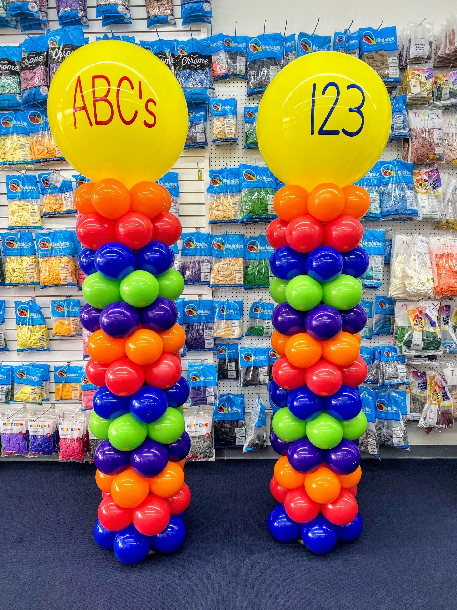 Two columns of colorful balloons with the letters abcs and 123 on them