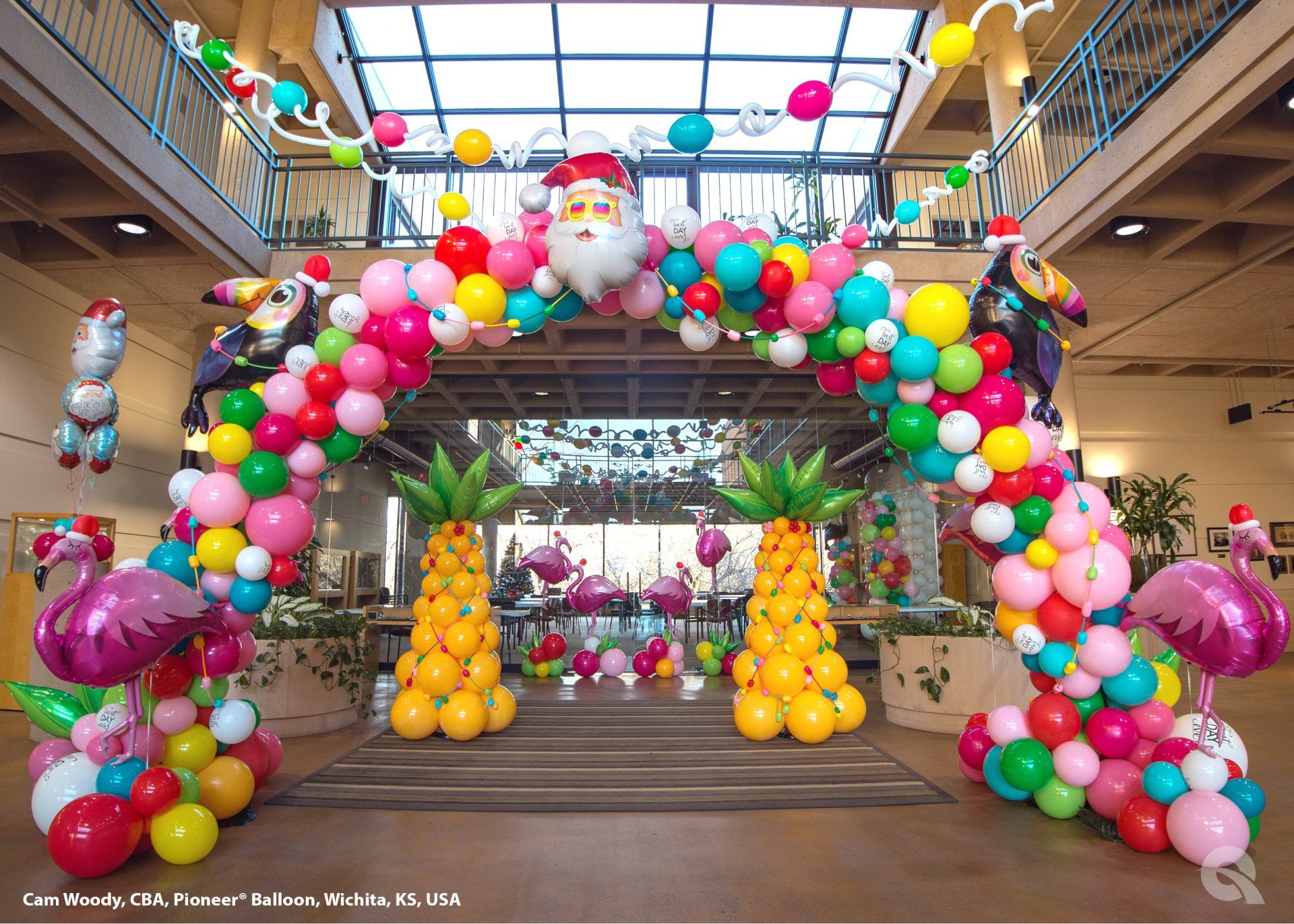 A large arch made of colorful balloons in a building.