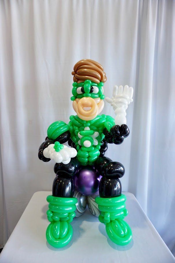 A green lantern made out of balloons is sitting on a table.