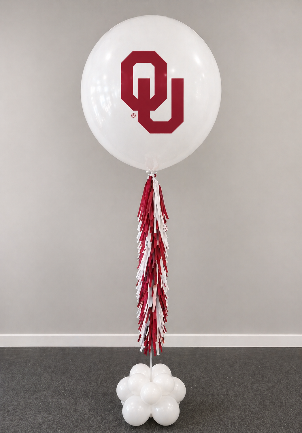 A jumbo helium balloon personalized with OU sooners College logo and color, with matching colored tassels..