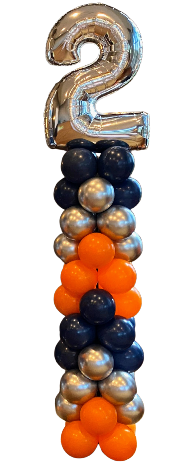 A bunch of black and gold balloons stacked on top of each other.